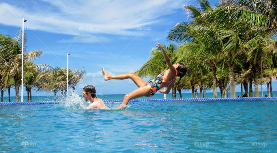 Two brothers having fun in the resort pool during their summer vacation