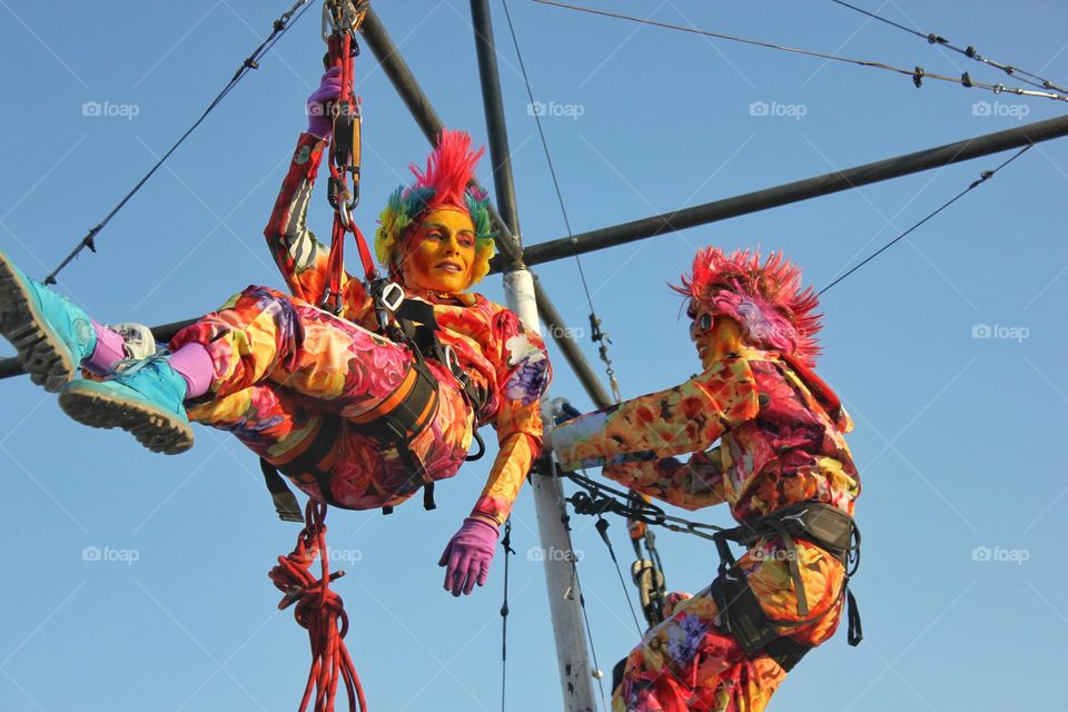 acrobat girl hanging in the air on a safety rope
