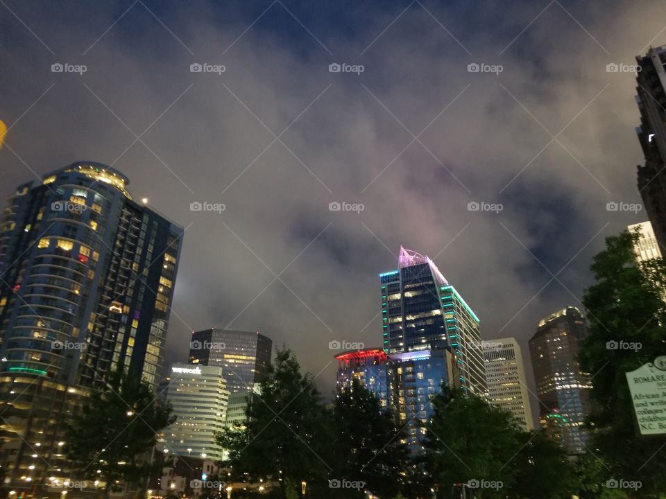 Dark cloudy & stormy Uptown Charlotte night skyline with high buildings lit