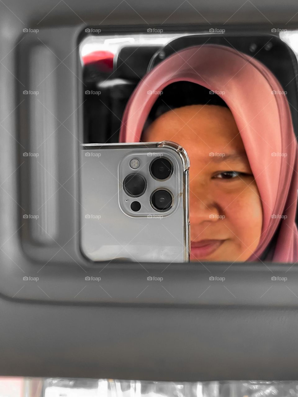 Reflection of self in a car using a smartphone 