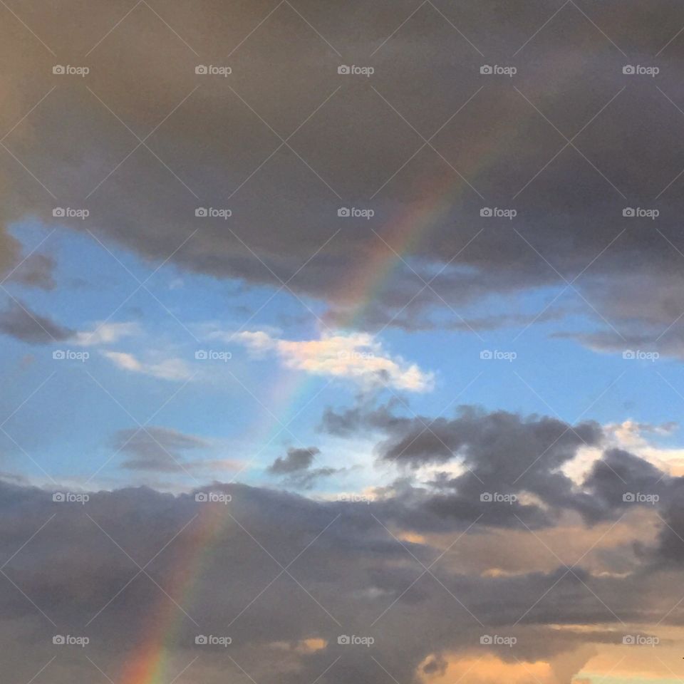 Gray skies meet a colorful rainbow after a storm 