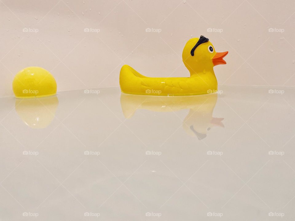 Yellow rubber ducky in the bathtub, yellow rubber ducky reflections in the water, rubber yellow ducky, bathtime for kids 