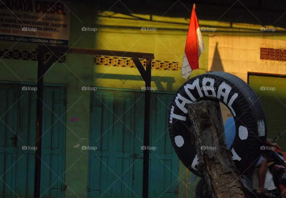 Indonesian repair tire symbol aside of roadway. Being easy for known by the symbol : tire and the letter of : Tambal Ban . Because not all the mechanic may interest to do the job.