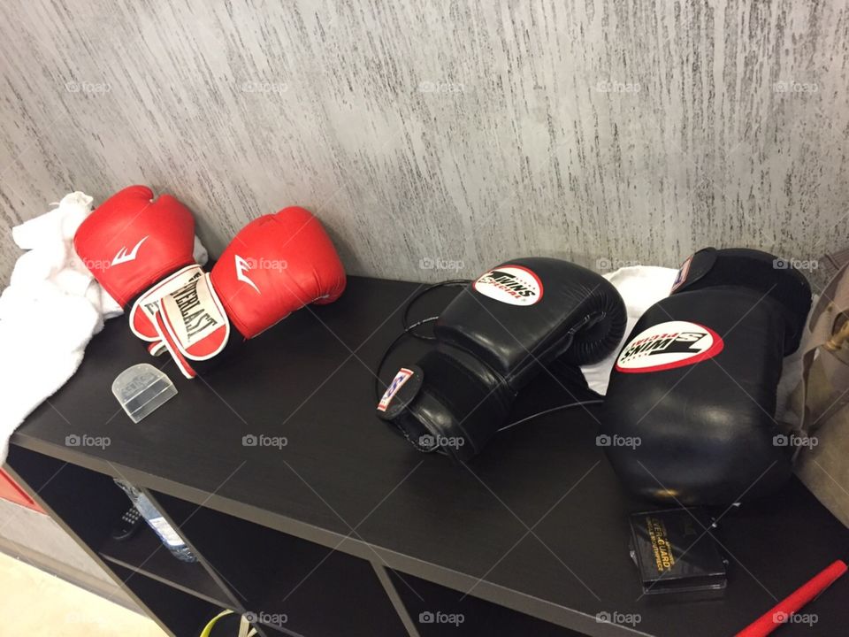 Boxing gloves after workout is finished two pair, one in red one in black , in mma gym 