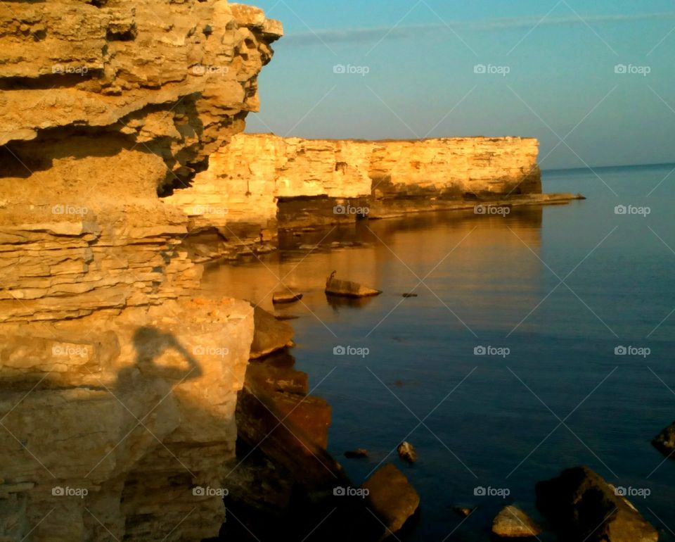 shadows people on the sea sunset rocks