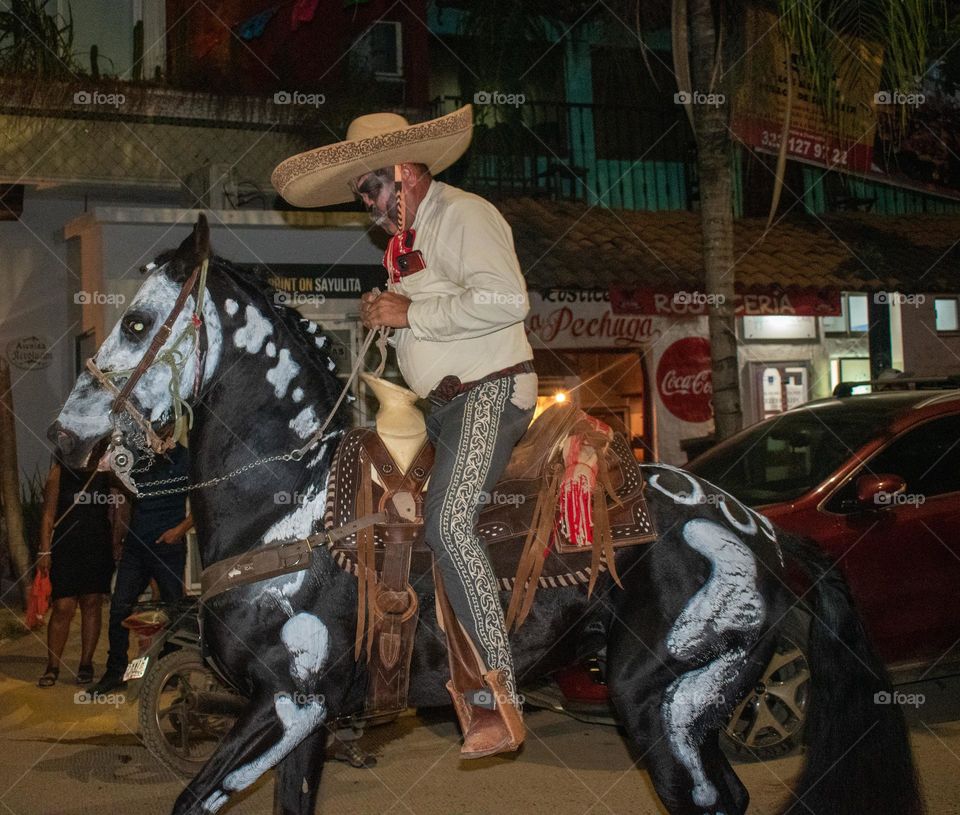 Charro en caballo caracterizado de catrín 