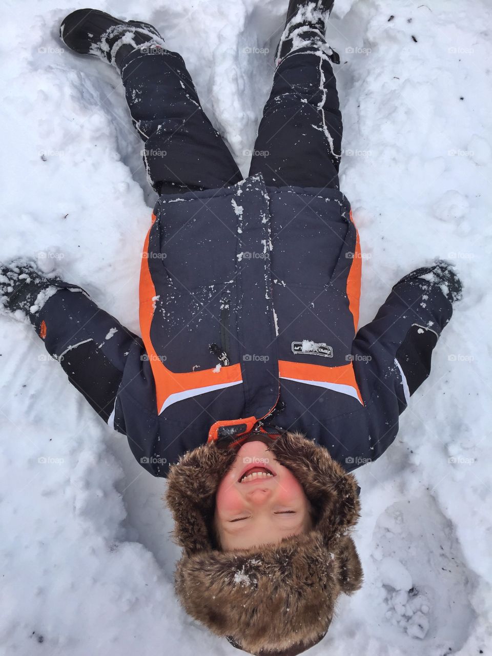 Cute boy lying on snow