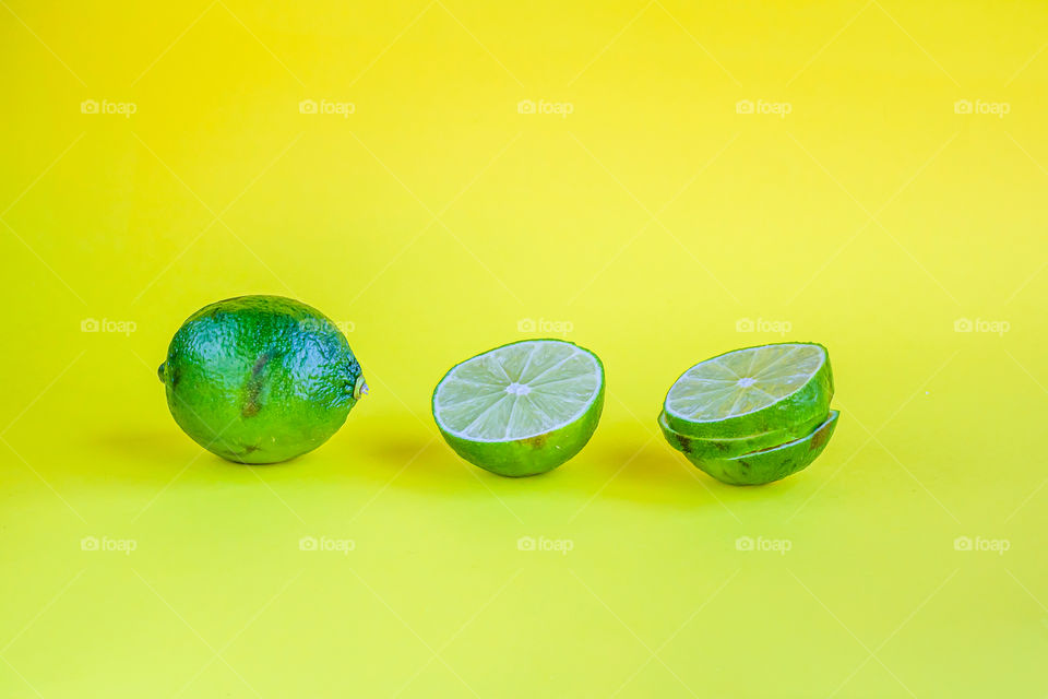 The limes on a yellow background. Copy space.
